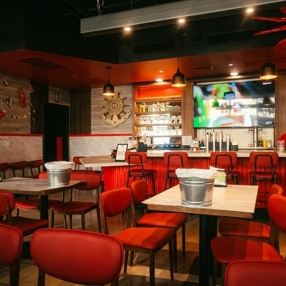 Interior of a restaurant with red chairs, wooden tables, a bar, and crab decorations.
